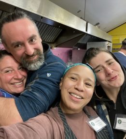 Four Common Ground Country Fair volunteers smile for a group selfie taken in MOFGA's Common Kitchen.